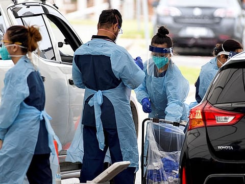 Healthcare workers administer COVID-19 tests at St Vincent's Hospital drive-through testing clinic at Bondi Beach in Sydney, on December 17, 2021.