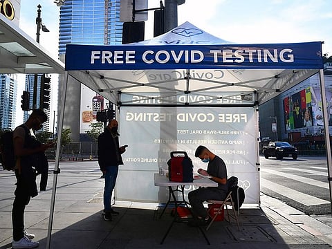 People wait in line for a free COVID-19 test in Los Angeles, California on December 21, 2021.