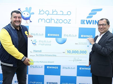 Hamdi, winner of Dh10 million, receives the cheque from Farid Samji, CEO of Ewings, the managing operator of Mahzooz.