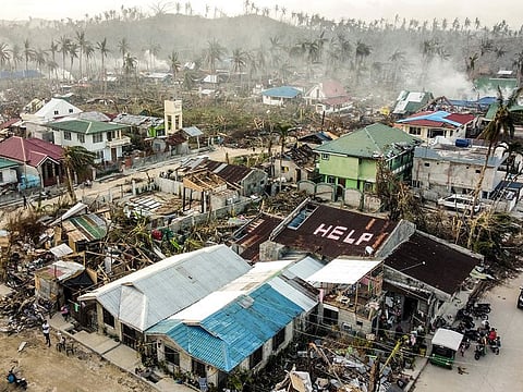 A 'help' sign is painted on the roof beside damaged homes caused by Typhoon Rai in Siargao island, Surigao del Norte, southern Philippines on Wednesday, Dec. 22, 2021.