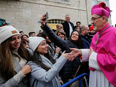 Pierbattista Pizzaballa, the Latin Patriarch of Jerusalem, greets people as he arrives to attend Christmas celebrations in Bethlehem, in West Bank on December 24, 2021.