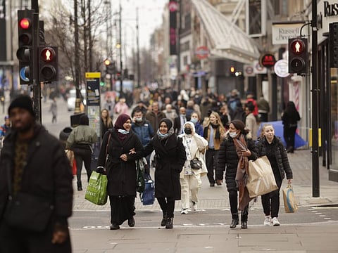 Shoppers on Oxford Street in central London on December 24, 2021. The number of people visiting London's major shopping district was down by almost a fifth on the last weekend before Christmas compared with pre-pandemic levels, a further sign of the toll the spread of the omicron variant is taking on beleaguered UK stores.