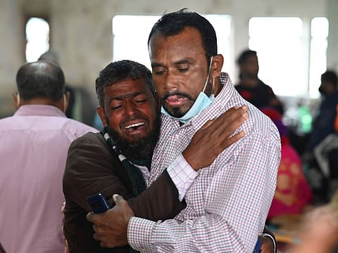 A person consoles his relative who is unable to find his five-year-old son travelling in a ferry which caught fire, at a government medical hospital, in Barishal, Bangladesh on December 24, 2021.