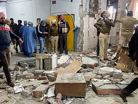 Police personnel inspect after a blast took place at a court complex, in Ludhiana on Thursday.