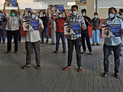 Stranded tourists hold placards with 'thank you' messages for His Highness Sheikh Mohammed bin Rashid Al Maktoum.
