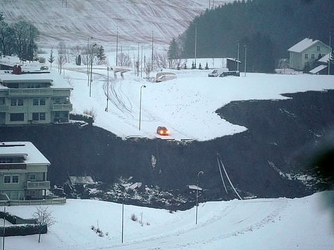 A car is stopped at the edge of a cliff after a landslide occurred in a residential area in Ask, near Oslo, on Wednesday.