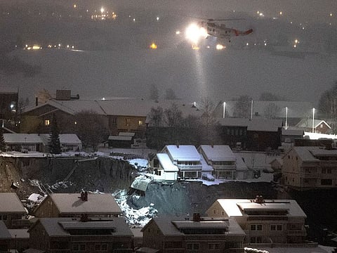 A rescue helicopter files over the site of a landslide in Ask, northeast of Oslo, early Thursday morning Dec. 31, 2020. A landslide smashed into a residential area near the Norwegian capital Wednesday.