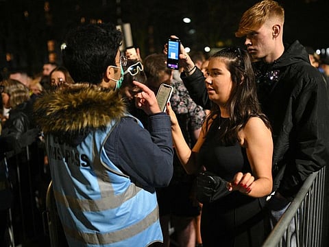 Revellers queue to have their Covid-19 status checked before being allowed to enter Depot Mayfield, a 10,000 capacity club in Manchester, north-west England on New Year's Eve, December 31, 2021.