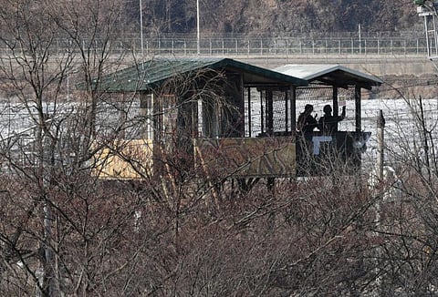 South Korean soldiers stand guard in a guard post as seen from the Imjingak peace park near the Demilitarized zone (DMZ) dividing the two Koreas in Paju on January 1, 2022. (Photo by Jung Yeon-je / AFP)