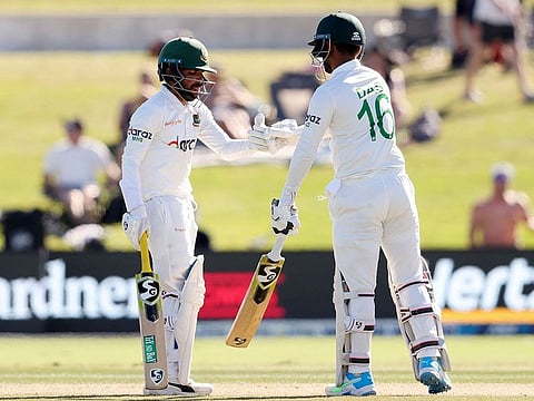 Bangladesh's batsmen Mominul Haque and Liton Das bump gloves at the Bay Oval in Mount Maunganui