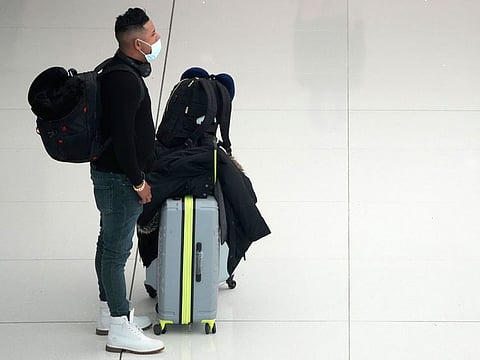 A lone traveller waits with his baggage in the terminal of Denver International Airport on December 24, 2021. More than 200 flights were cancelled by carriers out of Denver International because COVID-19 issues have created a shortage of workers.