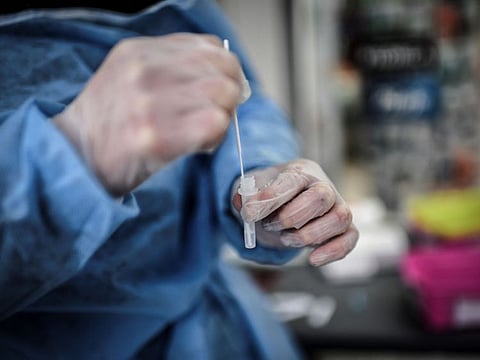 A medic holds up a sample collected from a patient tested for COVID-19 in Paris. The variant was identified in 12 people in the southern Alps around the same time that Omicron was discovered in South Africa last year. The latter mutation has since travelled the globe and kindled record levels of contagion, unlike the French one that researchers at the IHU Mediterranee Infection - helmed by scientist Didier Raoult - nicknamed IHU.