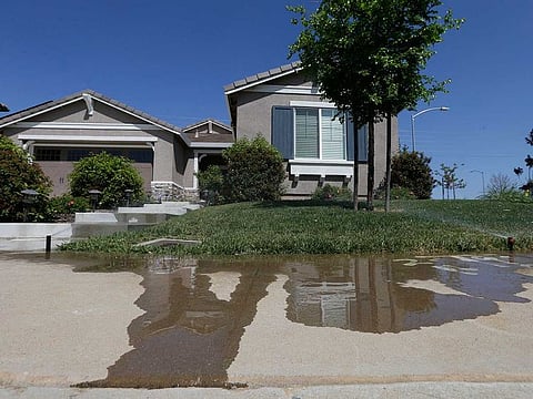 Water flows down a sidewalk from water sprinklers running at a home, Thursday, April 2, 2015, in Rancho Cordova, Calif. The State Water Resources Control Board voted Tuesday, Jan. 4, 2022 to adopt mandatory water use restrictions that prohibit excessive runoff from sprinklers.
