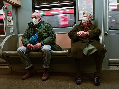 Commuters wearing protective masks sit in one of Milan's metro lines on January 4, 2022.