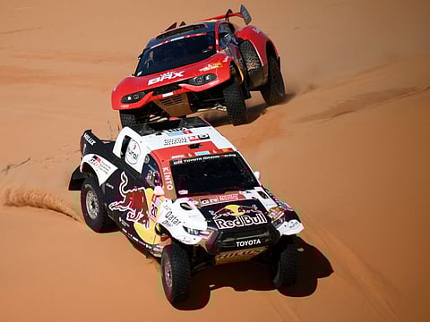 Toyota's driver Nasser Al Attiyah of Qatar and his co-driver Mathieu Baumel of France ride in front French driver Sebastien Loeb and co-driver Fabian Lurquin of Belgium during the Stage 5 of the Dakar 2022 on Thursday.