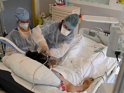 Nurses attend a patient infected with the COVID-19 at the intensive care unit of the Timone hospital, in Marseille, southern France on January 5, 2022.