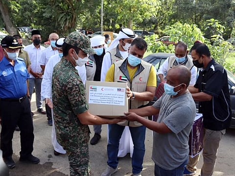 Some of the aid is distributed by Emirates Red Crescent workers.