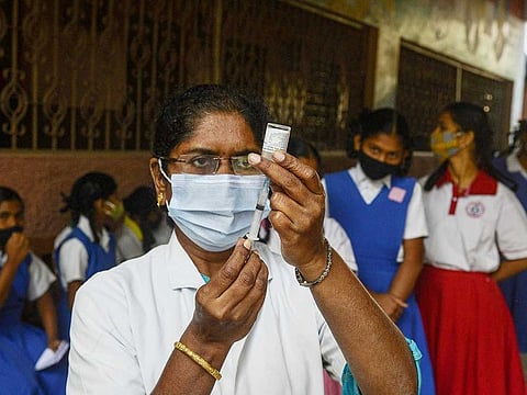 A health worker prepares a dose of COVID-19 coronavirus vaccine during a vaccination drive for people in the 15-18 age group, at a girls high school in Hyderabad on January 6, 2022.