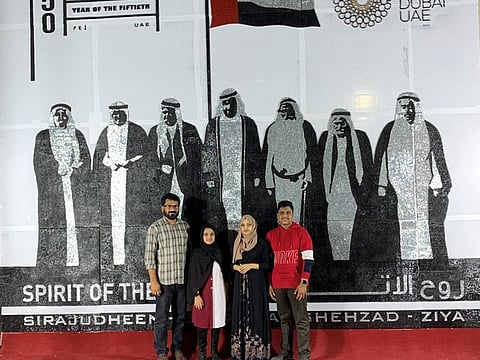 Sirajudheen and his family in front of the screw art at Abu Dhabi Malayalam Samajam.