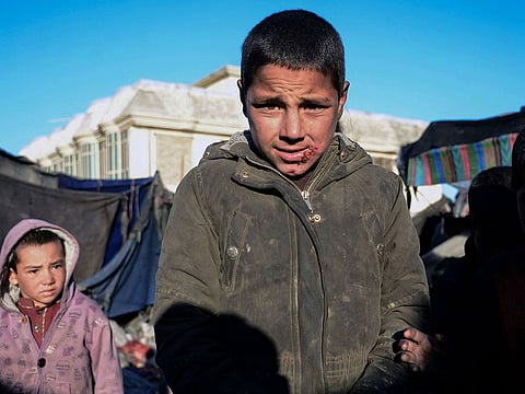 An Afghan boy reacts to the camera at a temporary camp set up near Kandahar city for the people who were internally displaced due to drought in the remote areas of Kandahar.