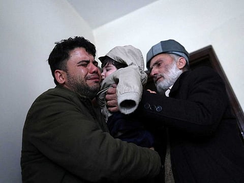 Hamid Safi, a 29-year-old taxi driver who had found baby Sohail Ahmadi in the airport, cries as he hands over Sohail to his grandfather Mohammad Qasem Razawi in Kabul, Afghanistan, January 8, 2022.