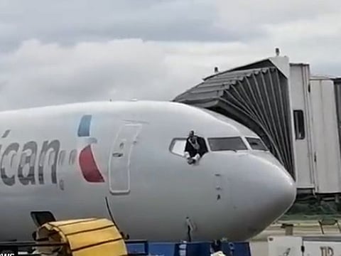 The passenger is seen at the window of the American Airlines jet.