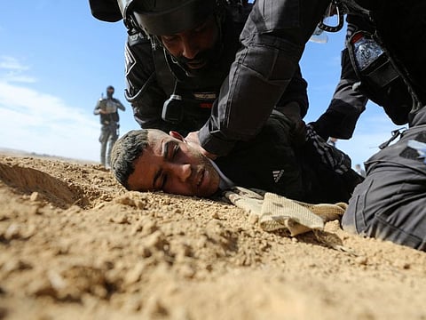 Israeli security forces detain a Bedouin man during a protest against forestation at the Negev desert village of Sawe Al Atrash, southern Israel January 12, 2022.