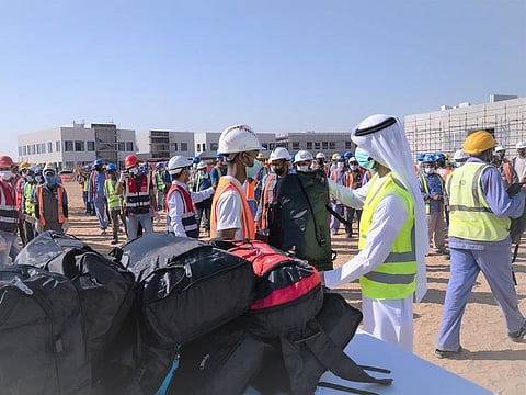 Workers receive bags of winter clothes in the 'Warm Winter' campaign in Sharjah