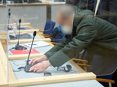 The defendant, former Syrian intelligence officer Anwar Raslan, fixes his microphone in the courtroom at a courthouse in Koblenz, western Germany, on January 13, 2022 on the last day of his trial where he was sentenced to life in jail for crimes against humanity.