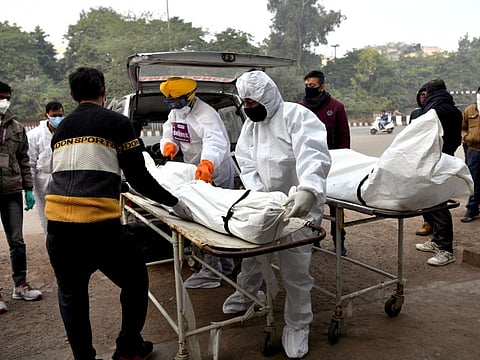 Volunteers carry body of COVID-19 victim for the final rites at crematorium in New Delhi on January 13, 2022.