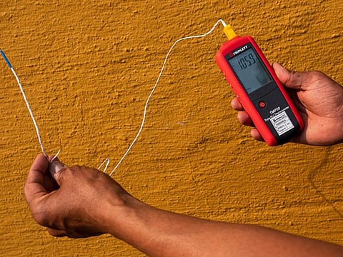 Vivek Shandas, a professor of climate adaptation at Portland State University, takes a temperature reading of almost 106 degrees in downtown Thursday, Aug. 12, 2021, in Portland, Oregon. People have headed to cooling centres as the Pacific Northwest began sweltering under another major, multiday heat wave.