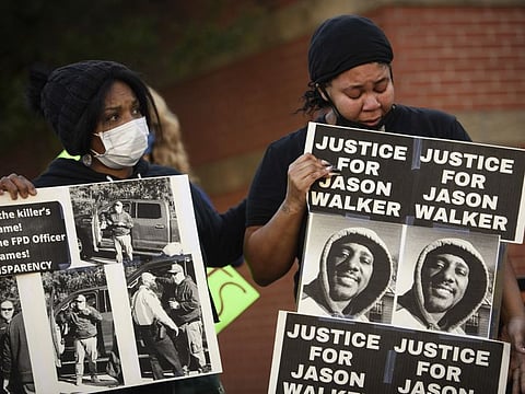 Pandora Harrington, right, cries as she holds a sign with an image of Jason Walker during a demonstration in front of the Fayetteville Police Department, Jan. 9, 2022, in Fayetteville, N.C. A judge has granted a North Carolina police chief's request to release body camera video recorded moments after last Saturday's fatal shooting of Walker by an off-duty sheriff’s deputy. The Fayetteville Observer reports that Senior Resident Superior Court Judge Jim Ammons issued his ruling Thursday, Jan. 13, 2022, two days after Fayetteville Police Chief Gina Hawkins filed the request.