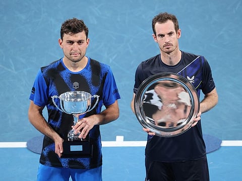 Aslan Karatsev of Russia (left) poses with the winner's trophy next to Andy Murray of Britain after the men's singles final match at the Sydney Classic tennis tournament in Sydney.