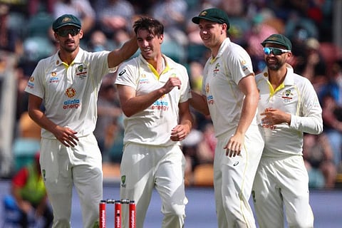 Australia's Pat Cummins, second left, celebrates with teammates after taking the wicket of England's Zak Crawley during their Ashes cricket Test match in Hobart, Australia.