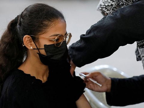 A girl receives a dose of COVID-19 vaccine in Karachi.
