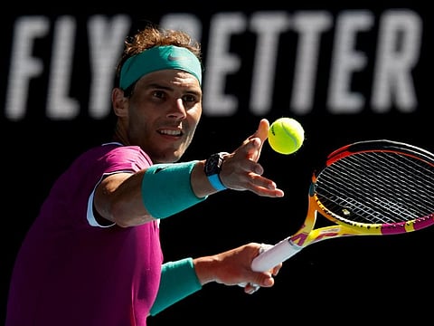 Spain's Rafael Nadal hits the ball into the stands to celebrate after winning the match against Marcos Giron of the US during their men's singles match on day one of the Australian Open tennis tournament in Melbourne.