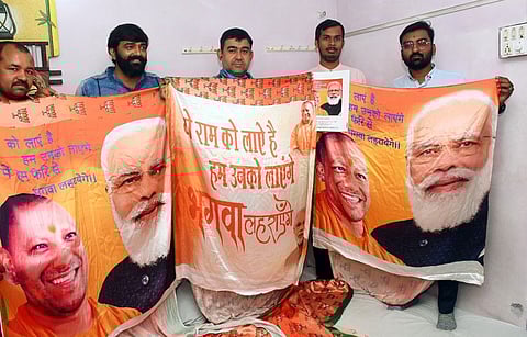 Manufacturers show the sarees printed with the pictures of Prime Minister Narendra Modi, Uttar Pradesh Chief Minister Yogi Adityanath and Bharatiya Janata Party (BJP) slogans, designed for the upcoming UP election campaign, in Surat on Tuesday.