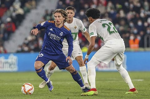 Real Madrid's Luka Modric (left) vies for the ball with Elche's Johan Mojica during a Copa del Rey match at Martinez Valero stadium in Elche, Spain.