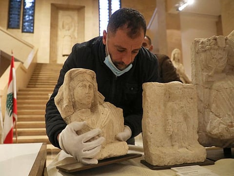 A man holds a Roman artefact from the ancient city of Palmyra during a handover ceremony hosted by Lebanon's National Museum in Beirut on January 20, 2022.