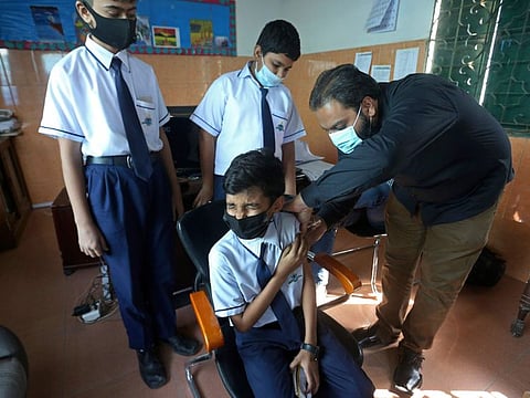 A student receives a doze of Pfizer COVID-19 vaccine at a school in Karachi, on January 20, 2022.