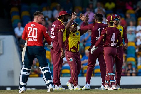 Jason Roy (left), of England, walks off the field, dismissed by Sheldon Cottrell, as Kieron Pollard and Odean Smith of West Indies celebrate during the first T20I at Kensington Oval in Bridgetown, Barbados.