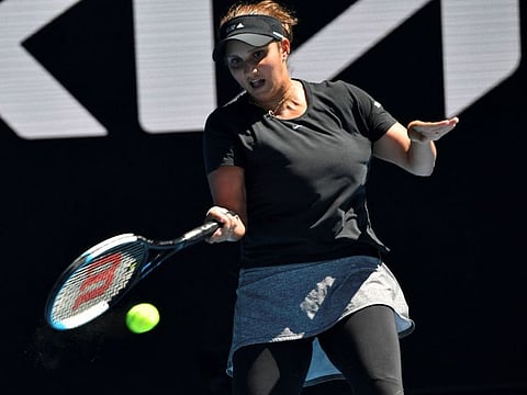 India's Sania Mirza hits a return while teaming with partner Rajeev Ram of the US against Australia's Jaimee Fourlis and compatriot Jason Kubler during their mixed doubles quarter-final match on day nine of the Australian Open tennis tournament in Melbourne.