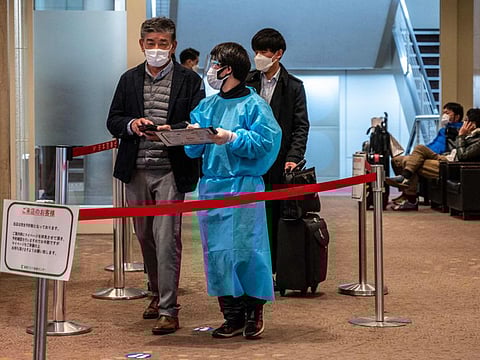 People line up for COVID-19 test outside at Tokyo's Haneda international airport on January 25, 2022. More than 370,000 people are left in limbo by Japan's coronavirus border rules, which bar almost all new arrivals and are the strictest in the G7.