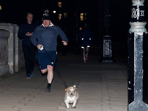 British Prime Minister Boris Johnson jogs with his dog Dilyn, in London, on January 26, 2022.