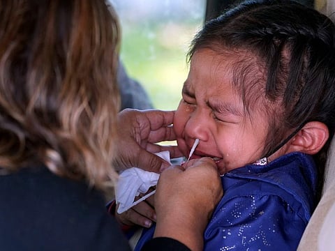 Sophie Gazmin, 4, being tested for COVID-19 by her mother Eligiia Parra at a No Cost COVID-19 Drive-Through testing provided the GUARDaHEART Foundation for the City of Whittier community and the surrounding areas at the Guirado Park in Whittier, California.