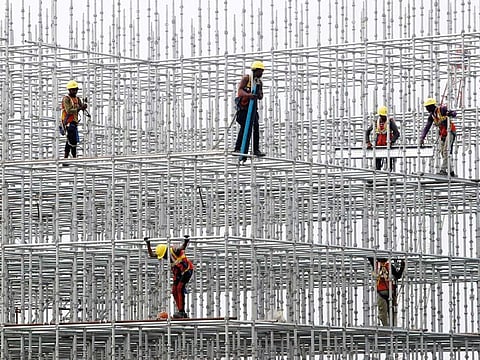 Construction workers seen on scaffolding for a bridge made for the coastal road project at Hajji Ali in Mumbai. India is focusing on infrastructure investments to bolster industrial demand
