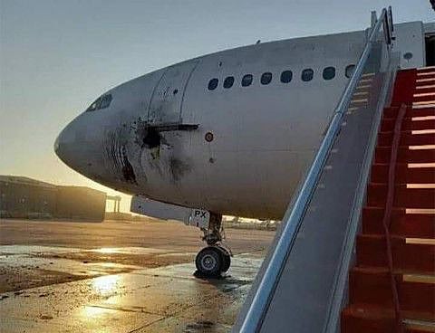 A handout picture released by the Facebook page of the Iraqi ministry of transportation, shows a damaged stationary aircraft on the tarmac of Baghdad airport, after rockets reportedly tragetted the runway, on January 28, 2022. - Six rockets were fired at the Iraqi capital's airport at dawn today, causing damage to a plane but no casualties, two security sources said.