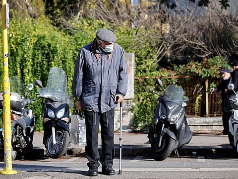 An old man wearing a face mask waits for a tram, as the region of Lazio makes face masks mandatory outdoors in all areas, in Rome, Italy.