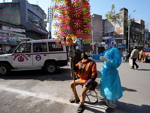 A health worker collects a swab sample from a vendor to test for COVID-19 in Jammu, on January 29, 2022.