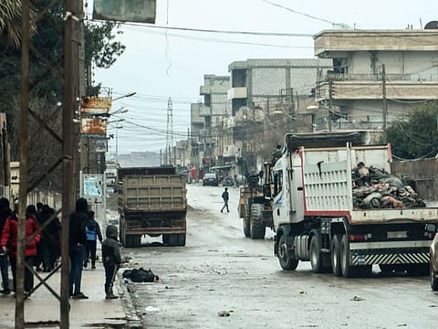People watch as bodies of alleged members of Daesh killed in recent confrontations, are transported in the back of a truck in the neighbourhood of Ghwayran in the northeastern Syrian city of Hasakeh, on January 29, 2022.